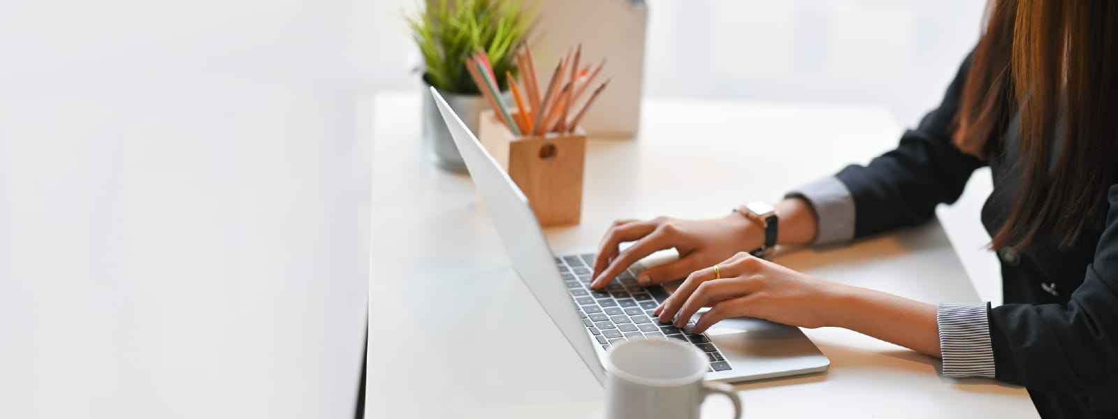Cropped image of creative woman hands typing on a computer laptop - Header