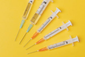 Syringes of different sizes on yellow background - TN